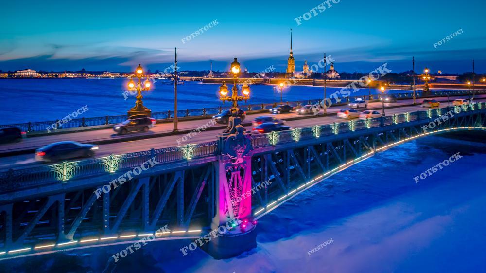На фотографии изображен зимний Санкт-Петербург с высоты птичьего полета. В кадре открывается панорамный вид на реку Неву, мосты Санкт-Петербурга и знаменитую Петропавловскую крепость, расположенную на Заячьем острове. Заснеженные улицы и архитектура исторического центра создают атмосферу настоящего зимнего Петербурга. Снимок выполнен с дрона и отлично передает масштаб города, красоту набережных и величие северной столицы России. Фотография подойдет для туристических проектов, оформления сайтов, рекламы, статей о Санкт-Петербурге и продажи изображений городской архитектуры и зимних пейзажей.